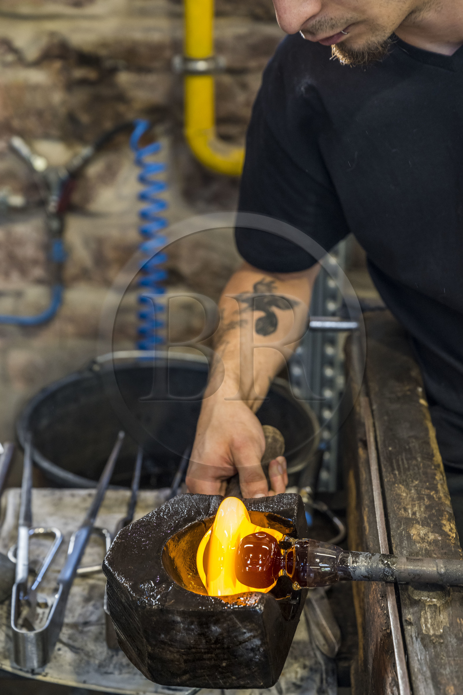 France, Moselle, Meisenthal, Centre international d'Art verrier (CIAV) (international glass centre), the blowing workshop, the prompter regulates the mass at home plate while performing a continuous rotation of his cane and preparation of the parison before passing to the mold
