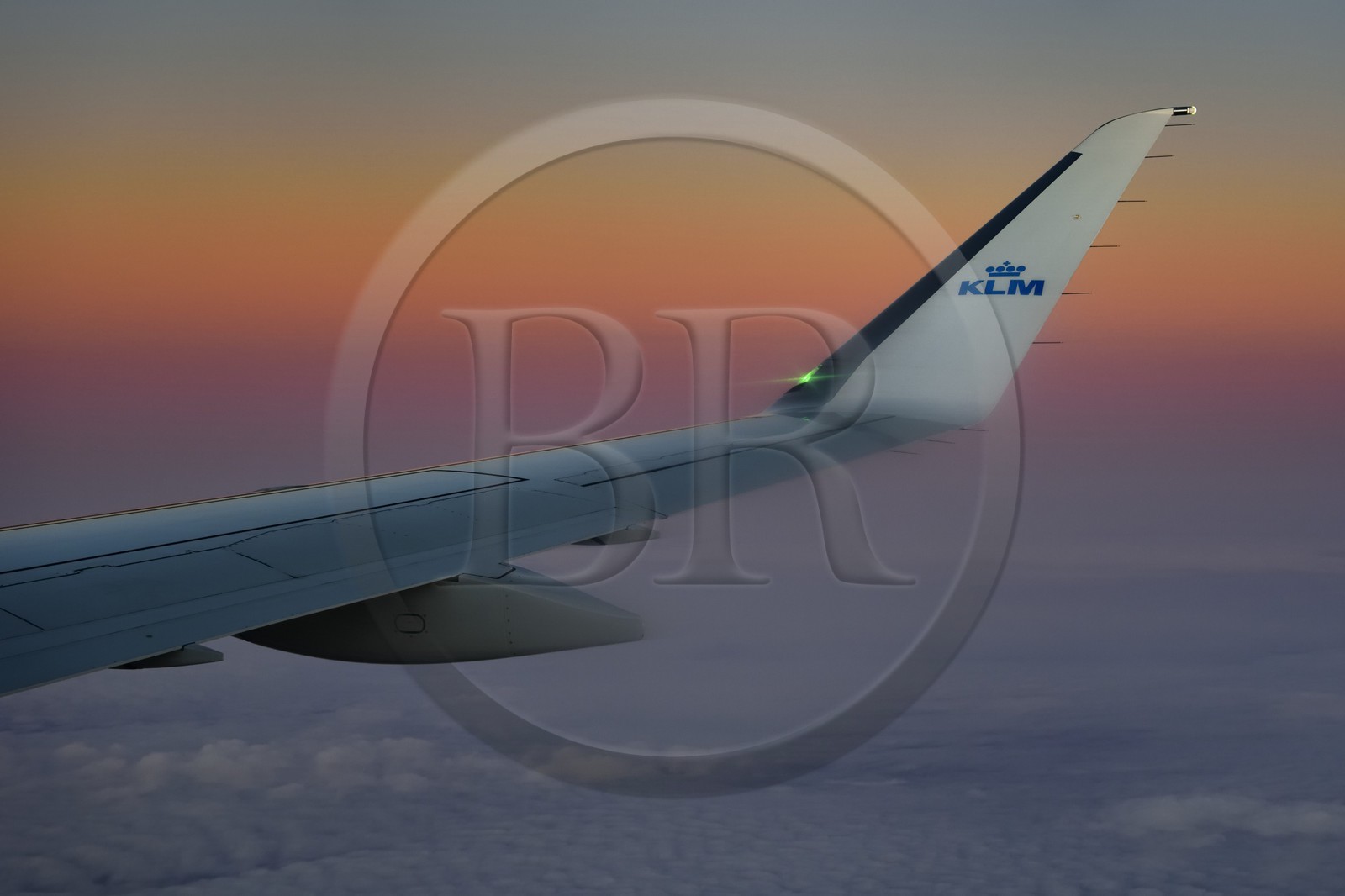 Norvège, aile d'un avion KLM en vol au dessus des nuages au coucher de soleil