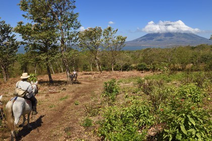 Nicaragua, Ometepe Island in Lake Nicaragua, riders trekking and the Conception volcano (1610 m) still active in the background
