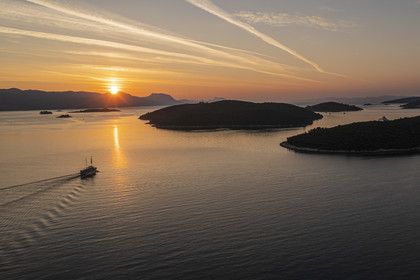 Croatie, Dalmatie, cote dalmate, bateau naviguant à l'aube vers l'archipel de Skoji dans le détroit entre la presqu'ile de Peljesac et Ile de Korcula (vue aérienne)