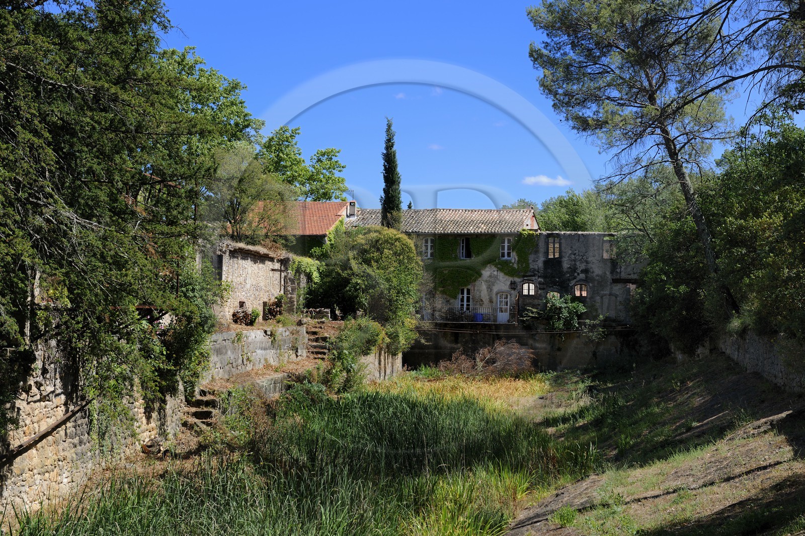 France, Hérault (34), Villeneuvette, ancienne manufacture royale, les ruines de l'usine au bord du grand bassin France, Hérault (34), Villeneuvette, ancienne manufacture royale, les ruines de l'usine au bord du grand bassin