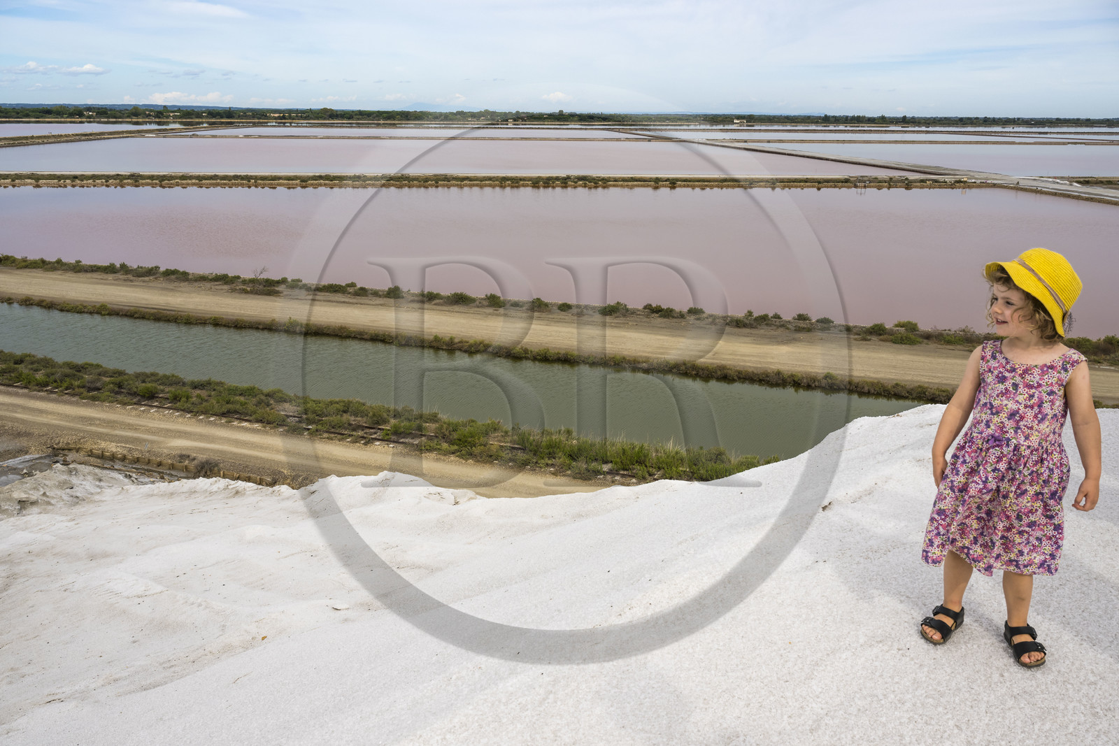France, Gard (30), Aigues-Mortes, le salin d'Aigues-Mortes (Salins du Midi), petite fille en visite au sommet d'une montagne de sel
