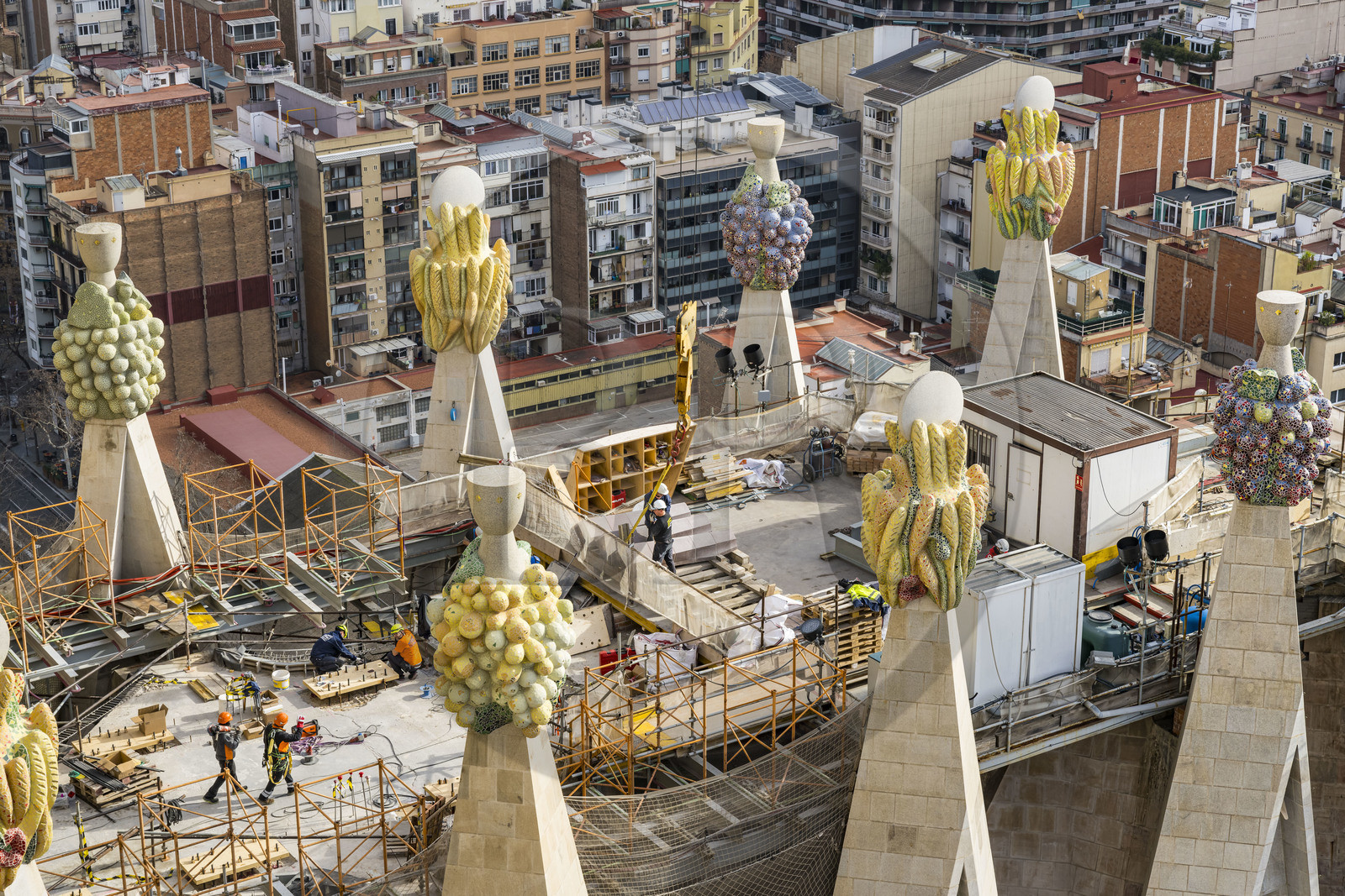 Espagne, Catalogne, Barcelone, quartier de l'Eixample, basilique de la Sagrada Familia de l'architecte du modernisme catalan Antoni Gaudi classée Patrimoine Mondial de l'UNESCO, sommets surmontés de mosaïques en forme de fruits entourant le chantier sur le toit de la nef à l'arrière de la future facade de la Gloire