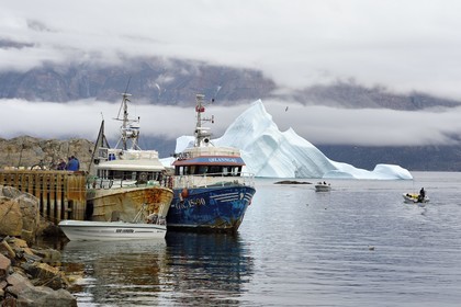 Groenland, cote ouest, Uummannaq, bateau de pêche dans le port et icebergs en arrière plan