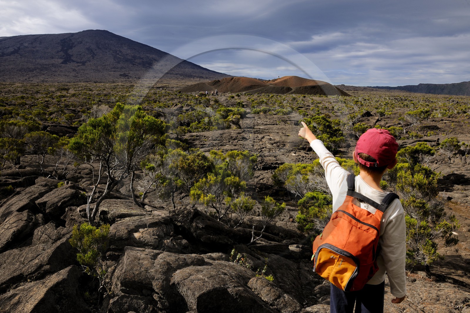 France, île de la Réunion, volcan du Piton de la Fournaise, classé Patrimoine Mondial de l'UNESCO, enfant pointant le cratère Formica Léo au premier plan et le cratère Dolomieu dans l'Enclos