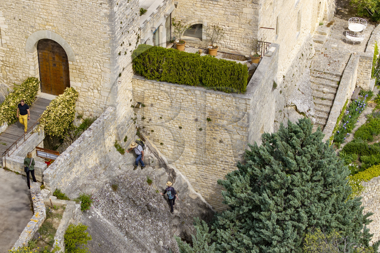 France, Vaucluse (84), Dentelles de Montmirail, le village perché de Crestet, montée de randonneurs sur le sentier à fleur de roche le long de son chateau du IXe siècle (vue aérienne)