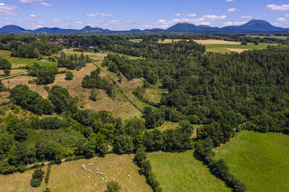 France, Puy de Dome, on the basalt mound of Saint Pierre Le Chastel overlooking the Sioule valley, the Chaine des Puys listed as World heritage by UNESCO, with the Puy de Côme on the left, the Grand Suchet and the Puy de Dôme volcano on the right (aerial view)