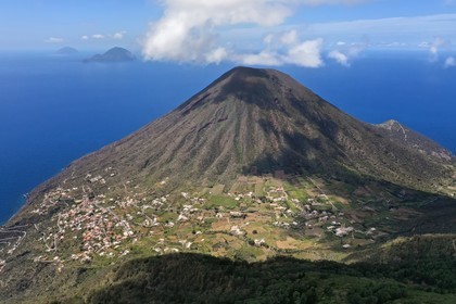 Italy, Sicily, Aeolian Islands, listed as World Heritage by UNESCO, Salina Island, the old volcano Monte dei Porri, the islands of Filicudi and Alicudi in the background (aerial view)