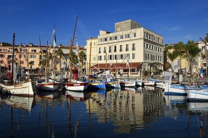 France, Var, Sanary-sur-Mer, traditional fishing boats called pointus in the port, Hotel de la Tour that wraps the Romanesque 13th century tower in the background