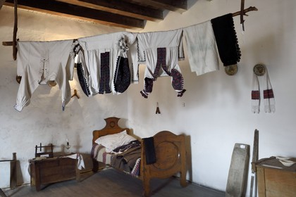 Romania, Transylvania, Hunedoara, Hunyad Castle or Corvin Castle, room with furniture and traditional clothes of the 19th century