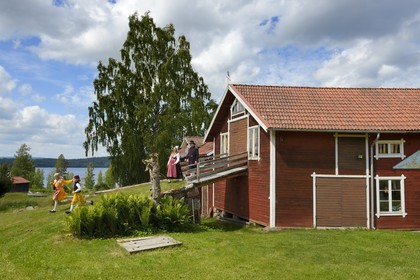 Suède, comté de Dalécarlie, région de Leksand, famille en costumes traditionnels pour les célébrations du solstice d'été dans le petit hameau de Sunnanäng sur la rive du lac Siljan