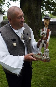 Poland, Lesser Poland, Carpathian Mountains, Eugeniusz Bogucki, wood-carver in traditional costume of the area presenting one of its sculptures
