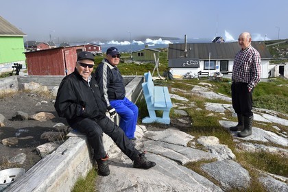 Groenland, cote ouest, Ile de Disko, habitants du village de Qeqertarsuaq et icebergs en arrière plan