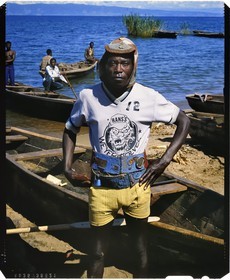 Burundi, province de Rumonge, groupe de pêcheurs au bord du lac Tanganyika, personnage haut en couleur, ce pêcheur Hutu surnommé le fou parvenait par près de 40°c à garder son bonnet en laine sur lequel il a accroché une croix de guerre allemande et une capsule de bière Primus, en arrière plan on apercoit la pointe de Burton et Speke située au Congo (reproduction plan-film inversible 4x5)