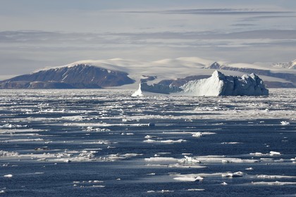 Groenland, cote Nord-Ouest, Smith sound au nord de la baie de Baffin, morceaux de glace de la banquise arctique et iceberg géant en arrière plan vers la côte canadienne de l'ile d'Ellesmere