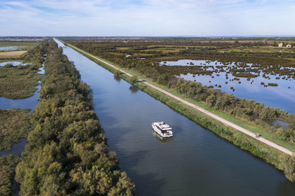 France, Gard (30), la Petite Camargue, navigation d'un bateau de plaisance Le Boat sur le canal du Rhône à Sète entre Gallician et Aigues-Mortes (vue aérienne) France, Gard, the Petite Camargue, navigation of a pleasure boat Le Boat on the Rhone to Sète Canal between Gallician and Aigues-Mortes (aerial view)