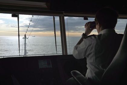 Groenland, cote Nord-Ouest, Baffin Bay, l'officier de navigation Maja Sabolic du bateau de croisière MS Fram de la compagnie Hurtigruten observe les icebergs à la jumelle