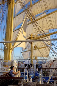 Caribbean sea, the five masted ship SPV Royal Clipper with every sail set, a passenger on the deck at sunrise