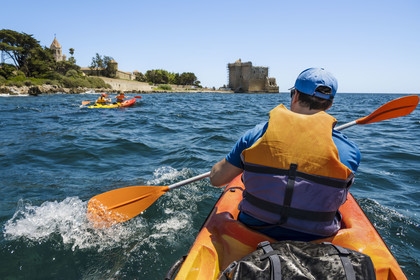 France, Alpes-Maritimes, Cannes, kayaking in the Lerins Islands, tour of the Saint-Honorat island from the south, the church of the Abbey of Lérins and the old fortified monastery in the background