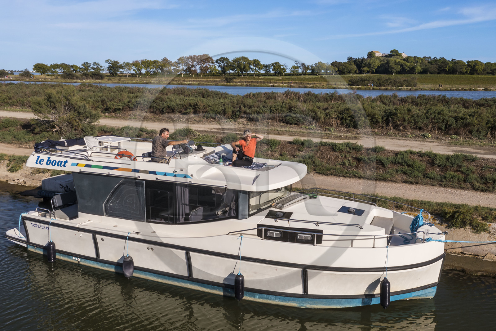 France, Hérault (34), Villeneuve-lès-Maguelone (Palavas-Les-Flots), bateau de plaisance Le Boat sur le canal du Rhône à Sète devant l'Ile de Maguelone et la cathédrale Saint-Pierre-et-Saint-Paul de Maguelone (vue aérienne) France, Herault, Villeneuve les Maguelone (Palavas Les Flots), pleasure boat Le Boat on the Rhone to Sète Canal in front of the Island of Maguelone and the Saint-Pierre-et-Saint-Paul de Maguelone cathedral (aerial view)