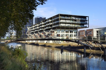France, Bas Rhin, Strasbourg, development of port du Rhin (Rhine's harbour) and conversion of breakwater of Bassin d'Austerlitz, presqu'ile Malraux (Malraux peninsula), former Mole Seegmuller warehouse turned into commerce and residential flats on the edge of the Austerlitz basin, the buildings the Black Swans in the background