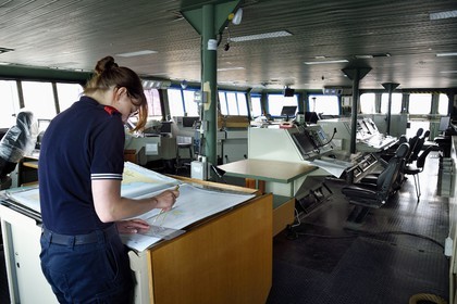 France, Var, Toulon, the naval base (Arsenal), the Charles de Gaulle nuclear-powered aircraft carrier on mid-life renovation, navigation bridge officer studying a map with her compass