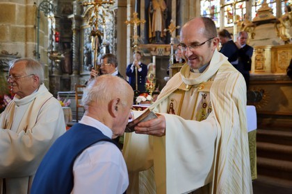 France, Finistere, Locronan, labelled Les plus Beaux Villages de France (The Most Beautiful Villages of France), Saint Ronan church, procession of the small Troménie, the priest gives the coasts relics of St. Ronan to kiss