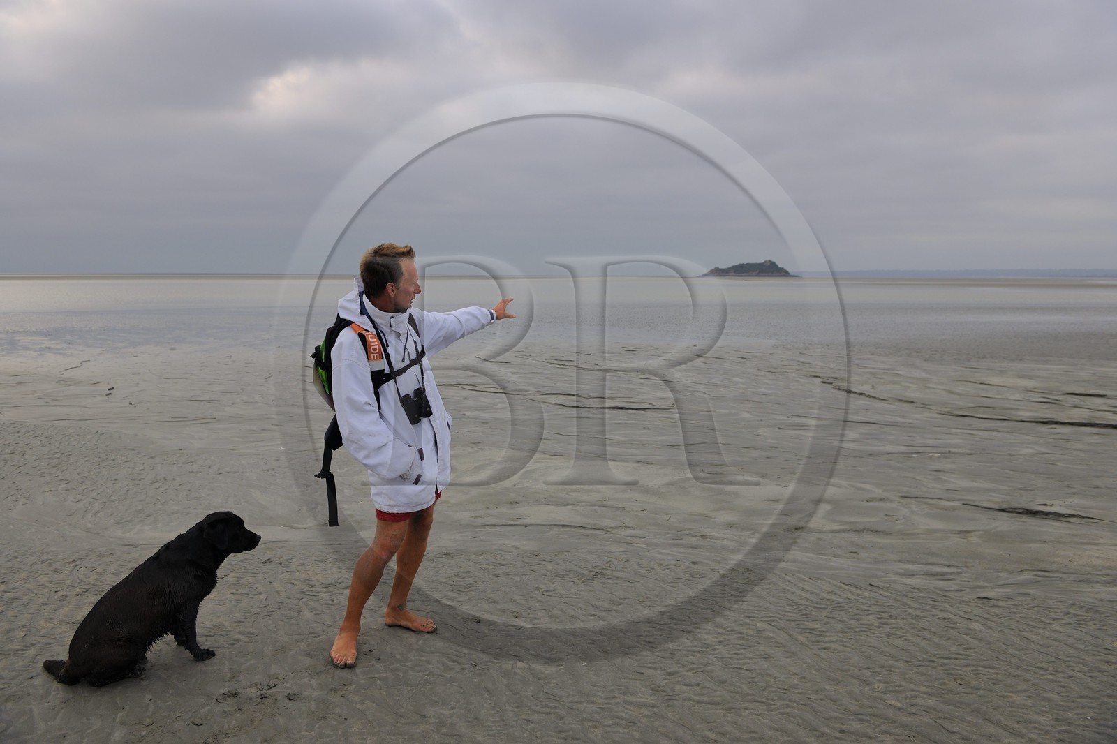 France, Manche (50), découverte de la Baie du Mont-Saint-Michel à pied avec le guide Romain Pilon qui pointe l'ile de Tombelaine France, Manche (50), découverte de la Baie du Mont-Saint-Michel à pied avec le guide Romain Pilon qui pointe l'ile de Tombelaine