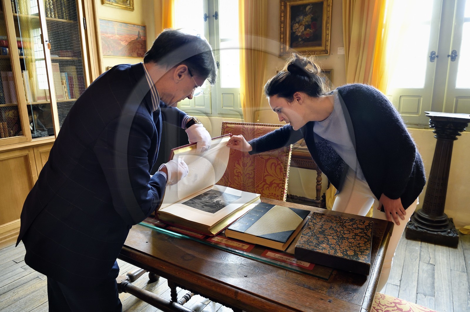 France, Aisne (02), Château-Thierry, Musée Jean de La Fontaine - Ville de Chateau-Thierry, le directeur du pole muséal Nicolas Rousseau et sa directrice adjointe Marie-Mileva Pavlovitch observant le livre des Fables de La Fontaine, édition illustrée (1867, in-folio) par Gustave Doré