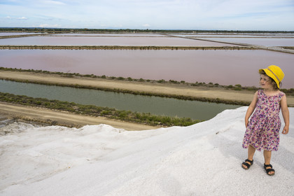 France, Gard (30), Aigues-Mortes, le salin d'Aigues-Mortes (Salins du Midi), petite fille en visite au sommet d'une montagne de sel