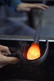 France, Moselle (57), Meisenthal, Centre international d’Art verrier (CIAV), l'atelier de soufflage, fabrication artisanale d'une boule de Noël, le souffleur régularise la masse au marbre tout en effectuant une rotation continue de sa canne