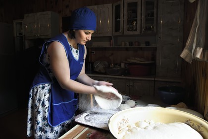 Georgia, Upper Svaneti (Zemo Svaneti), Mestia, Natia Loukhoutashvili prepares bread in her kitchen