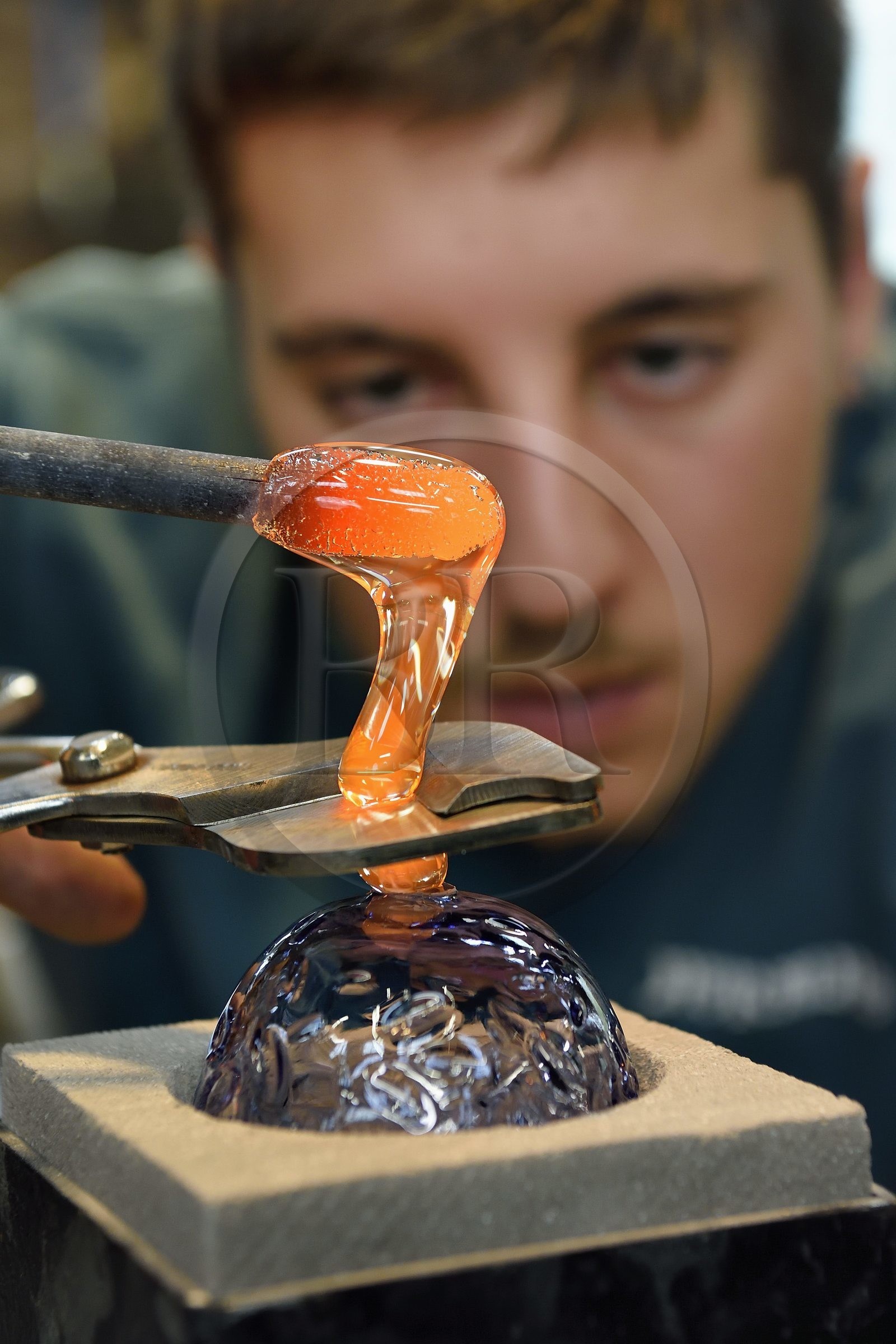France, Moselle (57), Meisenthal, Centre international d’Art verrier (CIAV), l'atelier de soufflage, fabrication artisanale d'une boule de Noël, pose de la pastille pour la création du crochet en verre France, Moselle (57), Meisenthal, Centre international d’Art verrier (CIAV), l'atelier de soufflage, fabrication artisanale d'une boule de Noël, pose de la pastille pour la création du crochet en verre