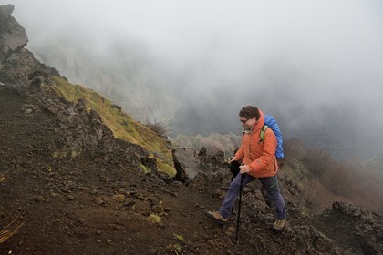 Italie, Sicile, Parc naturel régional de l’Etna, le Mont Etna, classé Patrimoine Mondial de l'UNESCO, randonneurs en bordure de la Valle del Bove qui correspond à un effondrement d’une des parois de l’Etna créant un champ de roches volcaniques de 7 km par 6 km