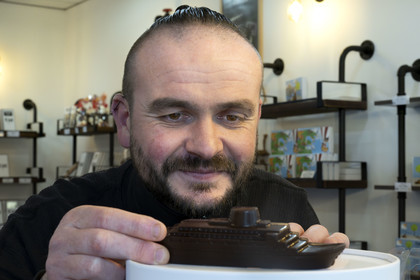 France, Loire-Atlantique, Saint-Nazaire, Master chocolatier Guillaume Menand in his shop with one of his creations, the ocean liner