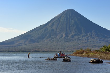 Nicaragua, Ometepe Island in Lake Nicaragua, village of Merida, woman doing her laundry in the lake and the Conception volcano (1610 m) in the background