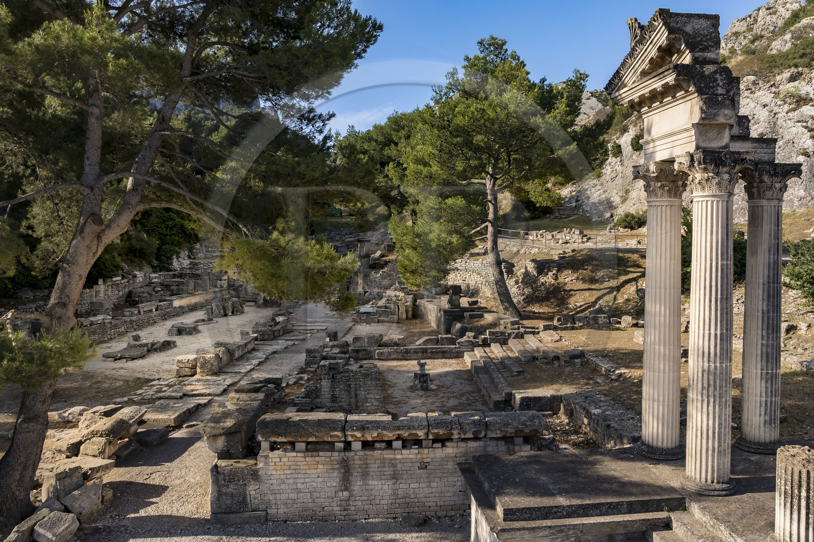 France, Bouches-du-Rhône (13), Parc Naturel Régional des Alpilles, Saint-Rémy-de-Provence, site archéologique de Glanum, colonnes et entablement reconstitués du petit temple géminé du premier forum au premier plan à droite