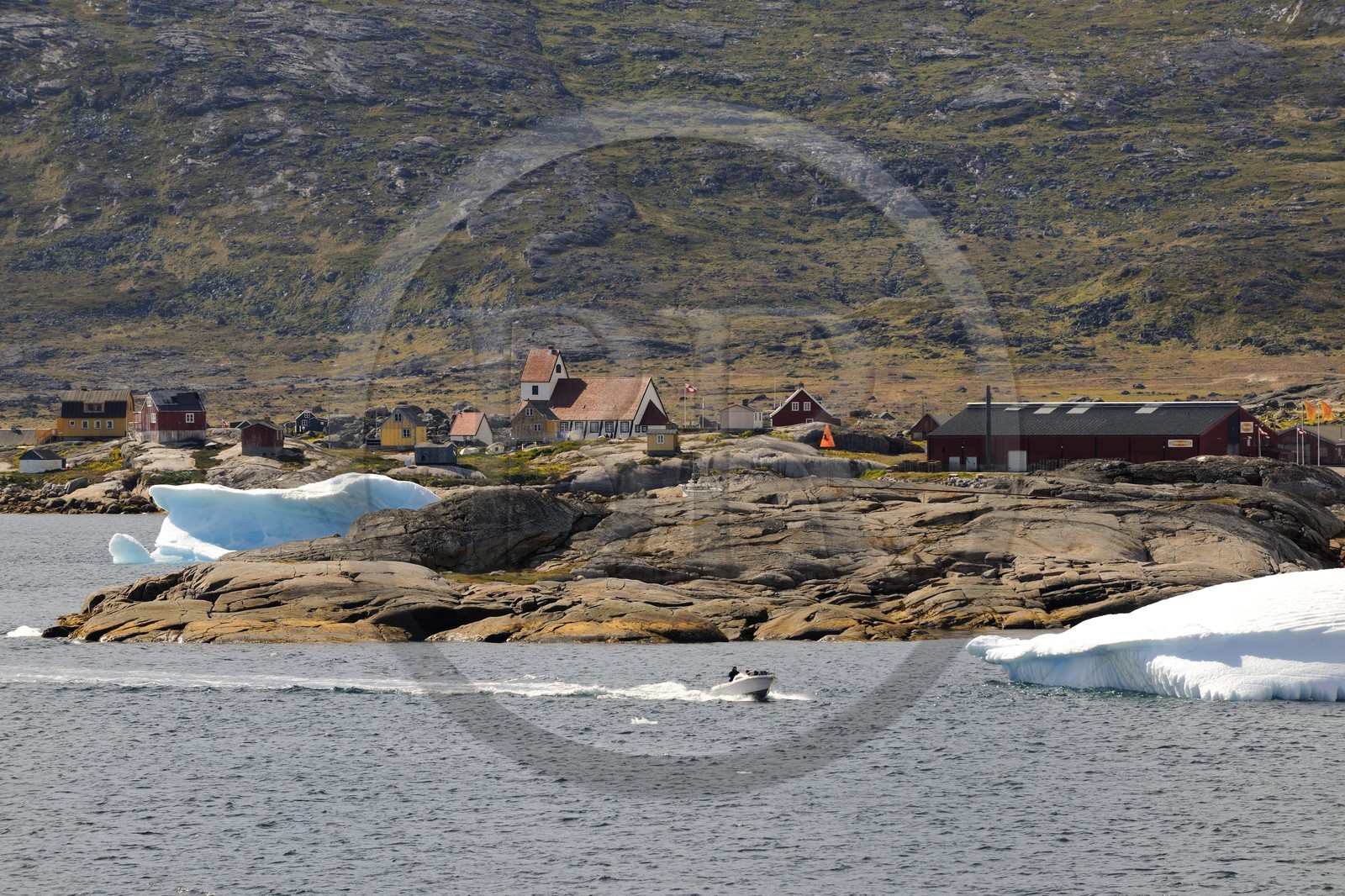Groenland, ville de Nanortalik et bateau à moteur progressant entre les icebergs dans la baie