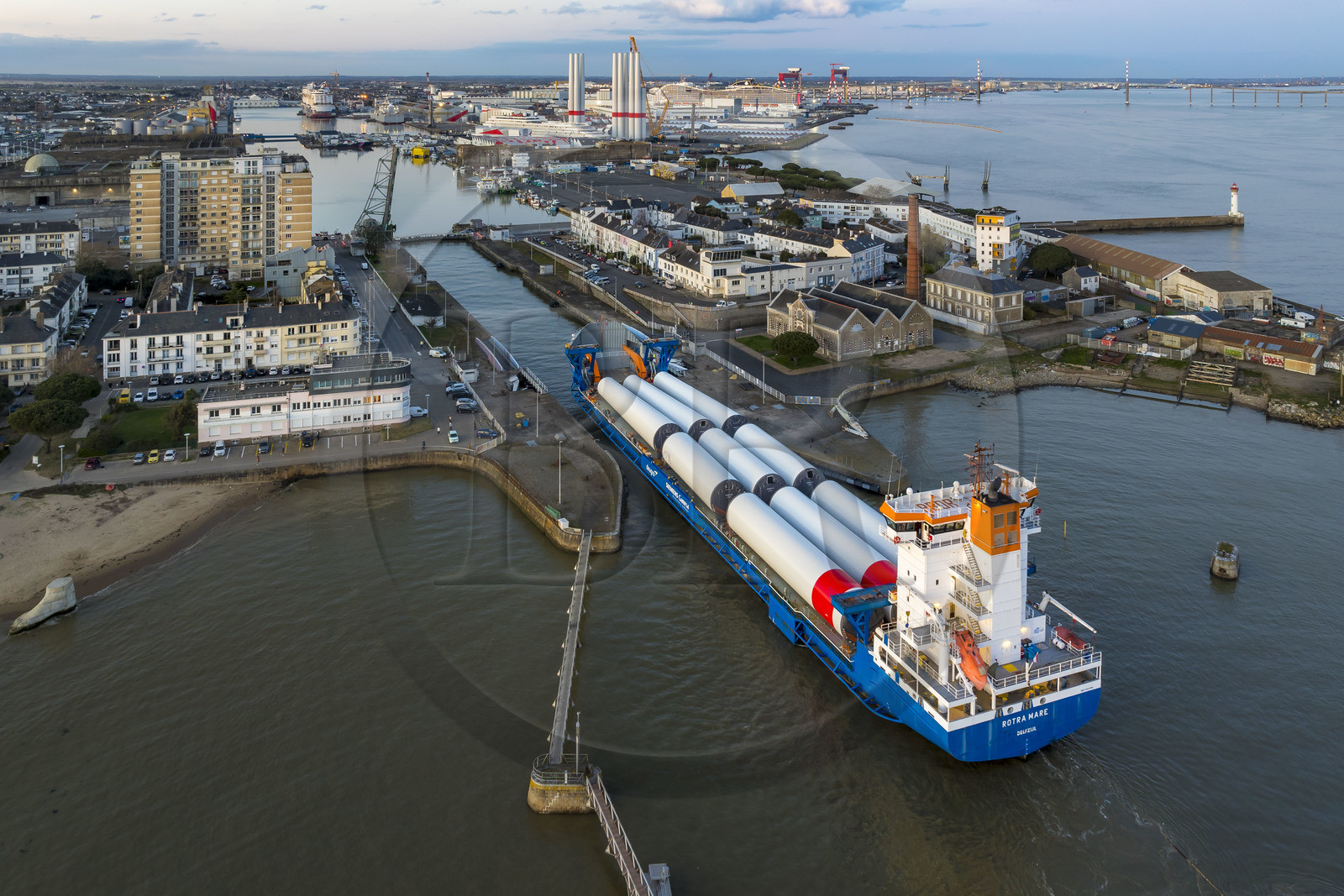 France, Loire-Atlantique (44), Saint-Nazaire, le General Cargo Rotra Mare transporte des sections des mats d'éoliennes et entre dans le bassin à flot du port (en arrière plan) par  l'écluse sud, qui est aussi le lieu de l’Opération Chariot lancée en 1942 par les Britanniques (vue aérienne)