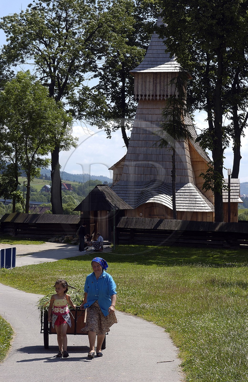 Pologne, Petite Pologne, Carpates, paysanne et sa petite fille tirant une charrette de foin devant l' église en bois Saint-Nicolas (15e siècle) classée Patrimoine Mondial de l'UNESCO dans le village de Debno Pologne, Petite Pologne, Carpates, paysanne et sa petite fille tirant une charrette de foin devant l' église en bois Saint-Nicolas (15e siècle) classée Patrimoine Mondial de l'UNESCO dans le village de Debno