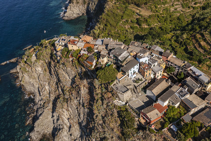 Italy, Liguria, Cinque Terre National Park listed as World Heritage by UNESCO, the village of Corniglia located at the top of a promontory overlooking the Mediterranean Sea at an altitude of about 100 m (aerial view)