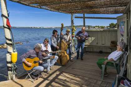 France, Hérault (34), Sète,  Pointe du Barrou sur les rives de l'étang de Thau, le groupe de musique Au Bois de mon cœur qui réinterprète les chansons de Georges Brassens, il est mené par le pêcheur sétois Jean-Louis Lambert au chant et à la guitare, Georges Cabaret à la guitare solo, Guy Blanc dit Guet au saxo alto, Denis Benito à la mandoline bluegrass et Tatiana à la contrebasse
