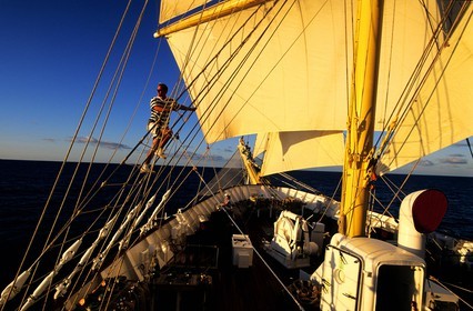 Caribbean sea, five masted ship SPV Royal Clipper with every sail set, a sailor claims into the sails