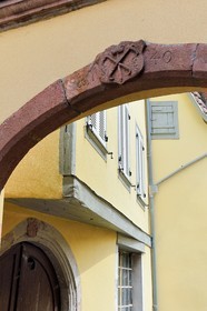 France, Haut Rhin, the Alsace Wine Route, Ribeauville, emblem of cooper corporation engraved on the pediment of a court