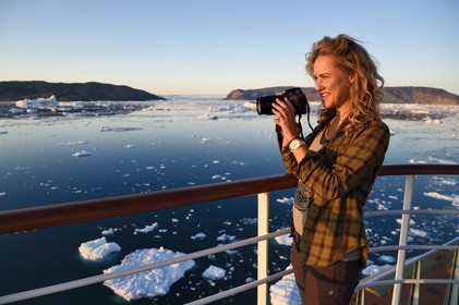 Greenland, west coast, Disko Bay, Hurtigruten MS Fram Cruise Ship moves between Icebergs in Quervain Bay at sunset and the glacier Kangilerngata sermia in the background