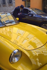 Italy, Lombardy, Milan, Fashion Quadrilateral (Quadrilatero della moda), Alfa Romeo Duetto Spider yellow cabriolet in front of the Four Seasons Hotel Milano