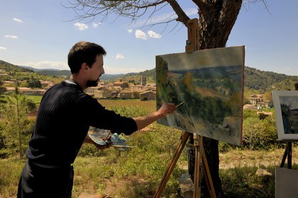 France, Aude, Lagrasse village, labelled Les Plus Beaux Villages de France (The Most Beautiful Villages of France), a painter in front of the village