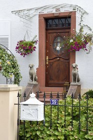 France, Bas-Rhin (67), Parc naturel régional des Vosges du Nord, Obersteinbach, chiens de garde en statues devant une maison