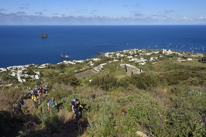Italy, Sicily, Aeolian Islands, listed as World Heritage by UNESCO, Stromboli island, hikers starting the ascent of the volcano, the village of Stromboli and the islet of Strombolicchio in the background