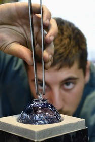 France, Moselle, Meisenthal, Centre international d'Art verrier (CIAV) (international glass centre), the blowing workshop, crafting a Christmas ball, finalization of the installation of the glass hook